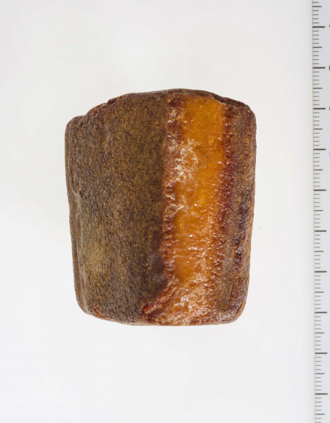 Półwytwór bursztynu kształtem zbliżony do sześcianu. Wyraźnie widoczne ślady szlifów i nawierceń.