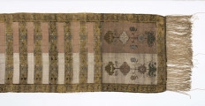 Pas kontuszowy czterostronny.
Ornament:
głowy- dwa motywy ukwiecinych łodyg umieszczonych w wazonach przypominajacych palmety- stylizowane , silna geometryzacja motywów. 
wciąż pasa- poprzeczne pólka z motywem wici kwiatowej i rzuty rozetek, na przemian
obrzeżenia- pionowe z motywem zgeometryzowanej wici kwiatowej poziome- jak w  pólkach 
kolor:pr. -  tło głów i pólek z wicią i obrzeżeń  żółte gładkie pólka w połowie różowe  w połowie różowe, wić brązowa kwiaty niebieskie, łososiowe i żółte
l. tło brązowe wzór słomkowy
Frendzla doszyta słomkowa.
