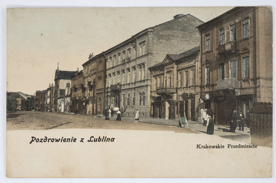 Pocztówka barwna z widokiem pierzei kamienic po parzystej stronie zabudowań przy ul. Krakowskie Przedmieście w Lublinie. 
AWRES: Widok w kierunku Starego Miasta na wysokości pl. Litewskiego. Ujęcie w poziomie. Kadr ustawiony na jedną stronę ulicy. Po prawej przylegające do siebie zabudowania dwu- lub trzykondygnacyjne. Na drugim z prawej budynku szyld z napisem „Fotografia”. Dalej widoczna fasada kościoła Kapucynów. W głębi gęsta zabudowa. Ulica brukowana. Na chodnikach przechodnie. U dołu cieniowana fotografia przechodzi w pas białego pola z nadrukiem w kolorze czarnym. Napisy informacyjne różnym krojem czcionki. Zdjęcie utrzymane w tonacji brązowej. 

REWERS: REWERS: Czarna linatura. Wyznaczone pole na adres i korespondencje oraz znaczek pocztowy. Nadruk z informacją o nakładcy w kolorze czarnym wzdłuż lewej krawędzi. Napisy w języku polskim, rosyjskim i francuskim. Brak korespondencji oraz śladów obiegu pocztowego.

