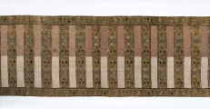 Pas kontuszowy czterostronny.
Ornament:
głowy- dwa motywy ukwiecinych łodyg umieszczonych w wazonach przypominajacych palmety- stylizowane , silna geometryzacja motywów. 
wciąż pasa- poprzeczne pólka z motywem wici kwiatowej i rzuty rozetek, na przemian
obrzeżenia- pionowe z motywem zgeometryzowanej wici kwiatowej poziome- jak w  pólkach 
kolor:pr. -  tło głów i pólek z wicią i obrzeżeń  żółte gładkie pólka w połowie różowe  w połowie różowe, wić brązowa kwiaty niebieskie, łososiowe i żółte
l. tło brązowe wzór słomkowy
Frendzla doszyta słomkowa.

