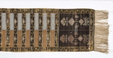 Pas kontuszowy czterostronny.
Ornament:
głowy- dwa motywy ukwiecinych łodyg umieszczonych w wazonach przypominajacych palmety- stylizowane , silna geometryzacja motywów. 
wciąż pasa- poprzeczne pólka z motywem wici kwiatowej i rzuty rozetek, na przemian
obrzeżenia- pionowe z motywem zgeometryzowanej wici kwiatowej poziome- jak w  pólkach 
kolor:pr. -  tło głów i pólek z wicią i obrzeżeń  żółte gładkie pólka w połowie różowe  w połowie różowe, wić brązowa kwiaty niebieskie, łososiowe i żółte
l. tło brązowe wzór słomkowy
Frendzla doszyta słomkowa.
