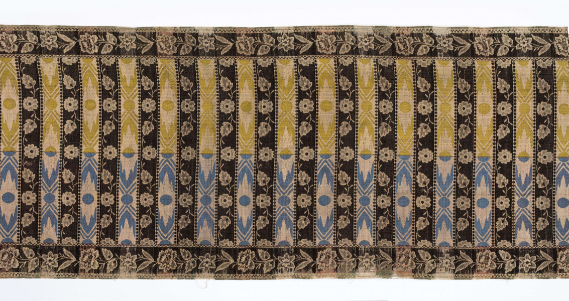 Pas kontuszowy czterostronny
Ornament: 
głowy - dwa motywy krzaczków kwiatowych wyrastających z liściastej rozety
środek - poprzeczne pólka na przemian z motywami wici kwiatowej i wydłużonych rombów z szelążkami
obrzeżenia - pionowe z motywami gałązek z kawiatami i liśćmi; poziome - motywy wici kwiatowej jak w pólkach
obwódki - w szachownicę, romby i groszki
Koloryt:
pr. - tło słomkowe, ornament różowy, biały, zielony, błękitny, jaznobrązowy
l. - tło czarne, jedynie w pólkach z rombamiw połowie błękitne, w połowie oliwkowozłote, ornament słomkowy
W narożnikach głów wytkana sygnatura: F/S (leżące)
Frędzla doszyta jedwabna, pleciona z nici kremowych z dodatkiem czarnych
