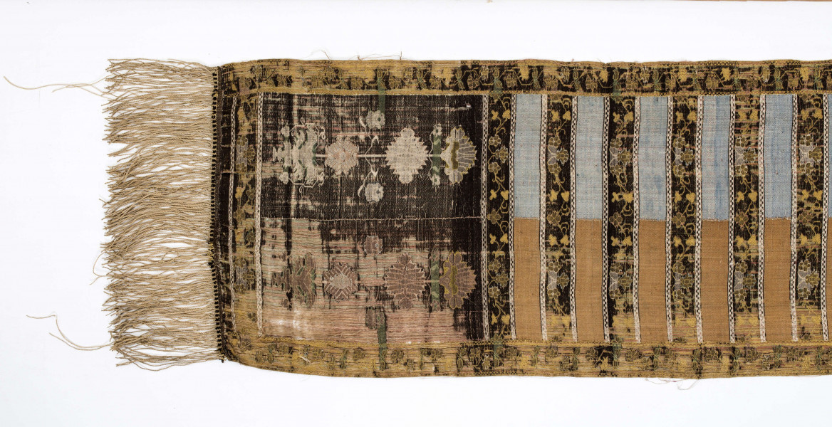 Pas kontuszowy czterostronny.
Ornament:
głowy- dwa motywy ukwiecinych łodyg umieszczonych w wazonach przypominajacych palmety- stylizowane , silna geometryzacja motywów. 
wciąż pasa- poprzeczne pólka z motywem wici kwiatowej i rzuty rozetek, na przemian
obrzeżenia- pionowe z motywem zgeometryzowanej wici kwiatowej poziome- jak w  pólkach 
kolor:pr. -  tło głów i pólek z wicią i obrzeżeń  żółte gładkie pólka w połowie różowe  w połowie różowe, wić brązowa kwiaty niebieskie, łososiowe i żółte
l. tło brązowe wzór słomkowy
Frendzla doszyta słomkowa.
