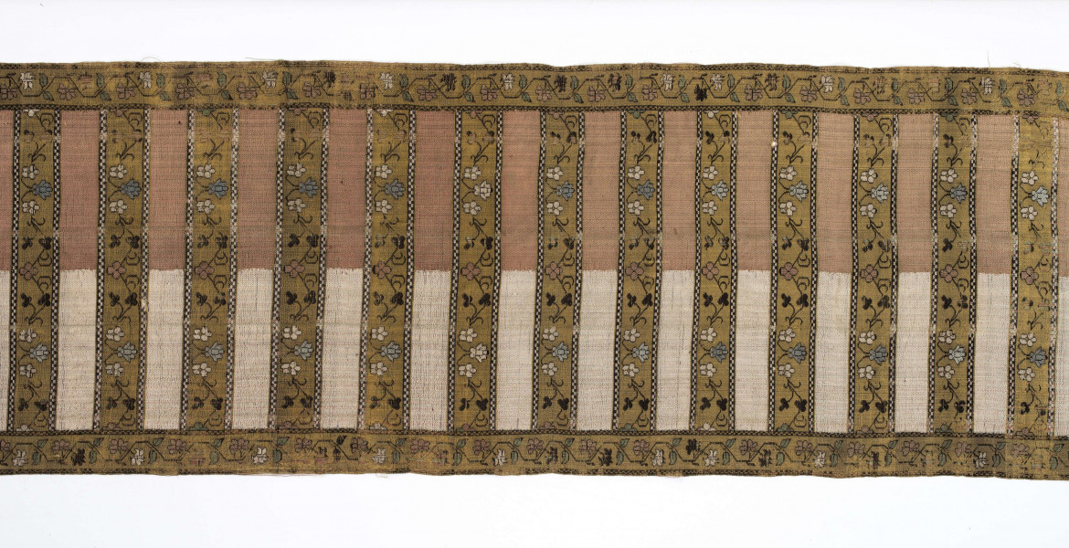 Pas kontuszowy czterostronny.
Ornament:
głowy- dwa motywy ukwiecinych łodyg umieszczonych w wazonach przypominajacych palmety- stylizowane , silna geometryzacja motywów. 
wciąż pasa- poprzeczne pólka z motywem wici kwiatowej i rzuty rozetek, na przemian
obrzeżenia- pionowe z motywem zgeometryzowanej wici kwiatowej poziome- jak w  pólkach 
kolor:pr. -  tło głów i pólek z wicią i obrzeżeń  żółte gładkie pólka w połowie różowe  w połowie różowe, wić brązowa kwiaty niebieskie, łososiowe i żółte
l. tło brązowe wzór słomkowy
Frendzla doszyta słomkowa.
