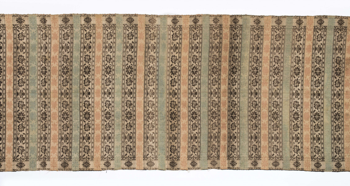 Pas kontuszowy dwustronny.
Ornament: 
głowy-trzy motywy stylizowanego kwiatu  goździka (każdy o czterech zgeometryzowanych płatkach)
wciąż pasa- poprzeczne pólka o kolejnych powtarzajacych się sekwencjach motywów:
-ciąg palmetek
-stylizowane kwiaty na tle łososiowym
-stylizowane kwiaty na tle zielonm
obrzeżenie- nieznacznie wyodrebnione dekorowane rozetką
Frędzla wysnuta z osnowy