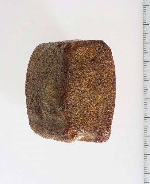 Półwytwór bursztynu kształtem zbliżony do sześcianu. Wyraźnie widoczne ślady szlifów i nawierceń.