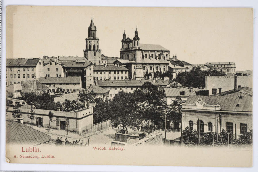 Pocztówka w sepii z widokiem zabudowań pomiędzy ulicami Bernardyńską i Żmigród oraz katedrą lubelską w Lublinie (ujęcie w poziomie).
AWERS: Na pierwszym planie skrzyżowanie ulic Bernardyńskiej i Żmigród. W oddali zabudowania ulicy Królewskiej. W tle widoczna Wieża Trynitarska oraz fasada frontowa i południowa katedry. Między budynkami liczne drzewa liściaste. Pod fotografią w lewym dolnym rogu na białym polu czerwonym kolorem nadruk z nazwą wydawcy, pośrodku z tytułem pocztówki.
REWERS: Linatura i nadruki w kolorze brązowym. Miejsce na korespondencje i znaczek pocztowy. U góry i u dołu nadruki z informacją w językach rosyjskim i francuskim. Wzdłuż lewej drukiem krawędzi nazwa wydawcy. Brak śladu obiegu pocztowego.