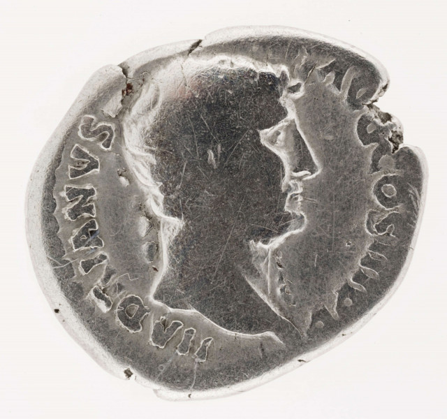 AV. Głowa cesarza w profilu w prawo. W otoku napis:
HADRIANVS - AVG COS III PP

RV. Stojąca w lewo Moneta, w jej rękach waga i róg obfitości. W otoku napis:
MONE[TA] AVG

Ubytek na obrzeżu.