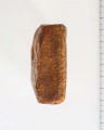 Surowiec wstępnie obrobiony. Kształt prostokątny, kolor pomarańczywy. Widoczne ślady obróbki.