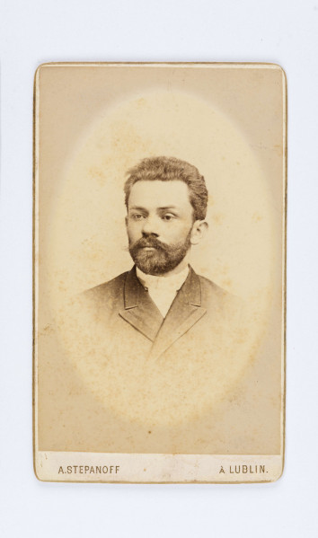 Fotografia pisarza z czasów narzeczeństwa. Z brodą i wąsami ubrany w białą koszule oraz marynarkę.