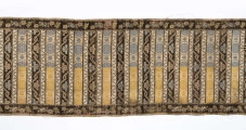 Pas 4-stronny. 
Ornament: głowy - krzaczki kwiatowe w wazonach; środek - poprzeczne pólka w układzie a,b,a,c (a - motyw wijacego sie wężyka, b - medaliony z rozetami, c - wić kwiatowa), obrzeża pionowe z gałązkami kwiatowymi, poziome - jak pólka c.
Koloryt: prawa strona - tło słomkowe, nieznacznie zróżnicowane w każdej połowie, zielen, błękit, żółty; lewa strona - tło brązowe głów i obrzeżeń, ornament - tło słomkowe, wzór j.w..
Fredzla doszyta jedwabna, pleciona, słomkowożółta