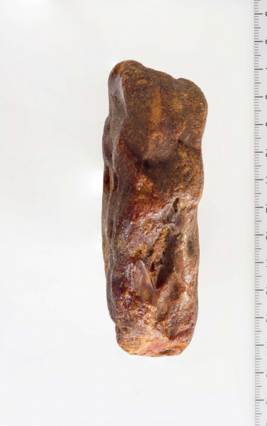 Surowiec, otoczak w całości pokryty korą. Na powierzchni widoczny szlif oraz negatywy odbić.