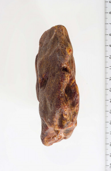 Surowiec, otoczak w całości pokryty korą. Na powierzchni widoczny szlif oraz negatywy odbić.