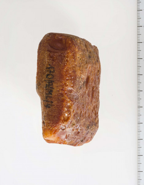 Surowiec wstępnie obrobiony. Kształt prostokątny, kolor pomarańczywy. Widoczne ślady obróbki.