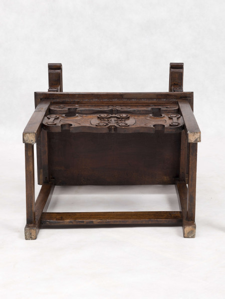 Fotel drewniany z  siedziskiem i oparciem drewnianym bez wyściełania, na prostych nogach z czterema łączynami. Nogi tylne przechodzą w ramiaki boczne oparcia. Oparcie prostokątne, lekko odchylone do tyłu. Zaplecek ażurowy złożony z dwóch bogato rzeźbionych desek:
- górna w ornamenty wolutowe wokół środkowago owalnego medalionu, z ozdobnie wyciątą dolną krawędzią i wyodrębnionym zwieńczeniem w kształcie przełamanego tympanonu z centralnym kartuszem
- dolna - węższa, powtarza główny motyw zdobienia.
Poręcze graniaste zakończone małymi wolutkami, u nasady rzeźbione liście akantu, podpórki w środkowej części rzeźbione. Płyta siedzenia prostokątna z rzeźbionym fartuchem z przodu. Łączyny boczne i tylna - graniaste, łączyna przednia w postaci deski o ozdobnym wykroju, rzeźbionej w ornamenty wolutowe.