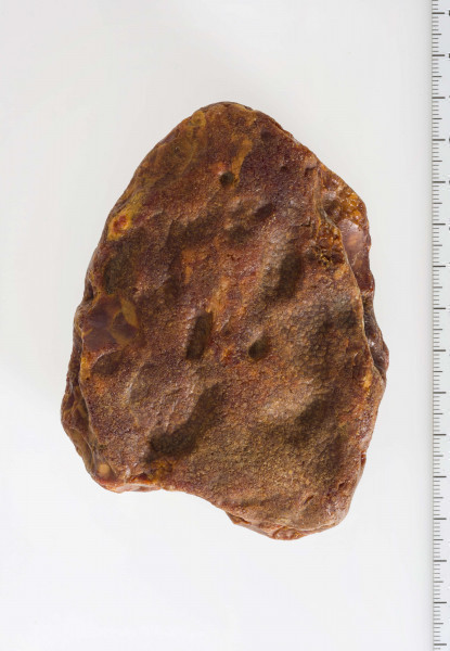 Surowiec, otoczak w całości pokryty korą. Na powierzchni widoczny szlif oraz negatywy odbić.