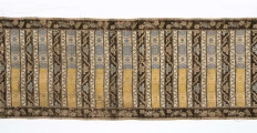 Pas 4-stronny. 
Ornament: głowy - krzaczki kwiatowe w wazonach; środek - poprzeczne pólka w układzie a,b,a,c (a - motyw wijacego sie wężyka, b - medaliony z rozetami, c - wić kwiatowa), obrzeża pionowe z gałązkami kwiatowymi, poziome - jak pólka c.
Koloryt: prawa strona - tło słomkowe, nieznacznie zróżnicowane w każdej połowie, zielen, błękit, żółty; lewa strona - tło brązowe głów i obrzeżeń, ornament - tło słomkowe, wzór j.w..
Fredzla doszyta jedwabna, pleciona, słomkowożółta