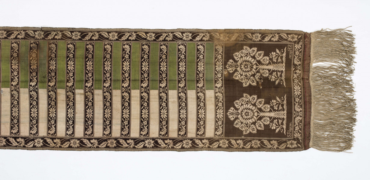 Pas kontuszowy czterostronny
Ornament
Głowy- motyw dwóch drzewek, których koronę stanowi owalna rozeta otoczona listkami, rozeta i listki wypełnione małymi kwiatkami. Drzewko wyrasta z lekko pofalowanego gruntu po bokach dwa małe krzaczki kwiatowe. 
Wciąż- pasa w poprzeczne pólka na przemian gładkie i z motywem wici kwiatowej.
Obrzeżenia- pionowe z motywem wici złożonej z kwiatów i listków palmowych, poziome jak w  pólkach.
Kolory: karmazynowy, błękitny, zielony, kremowy i brązowy
Pas sygnowany- w głowach tkany napis: S Filsjean Wkobyłce
Krótsze boki z doszytą długą frendzlą