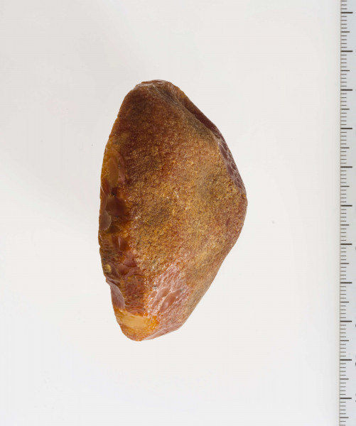 Pólwytwór bursztynu kształtem zbliżony do stożka. U podstawy wyraźne ślady obróbki.