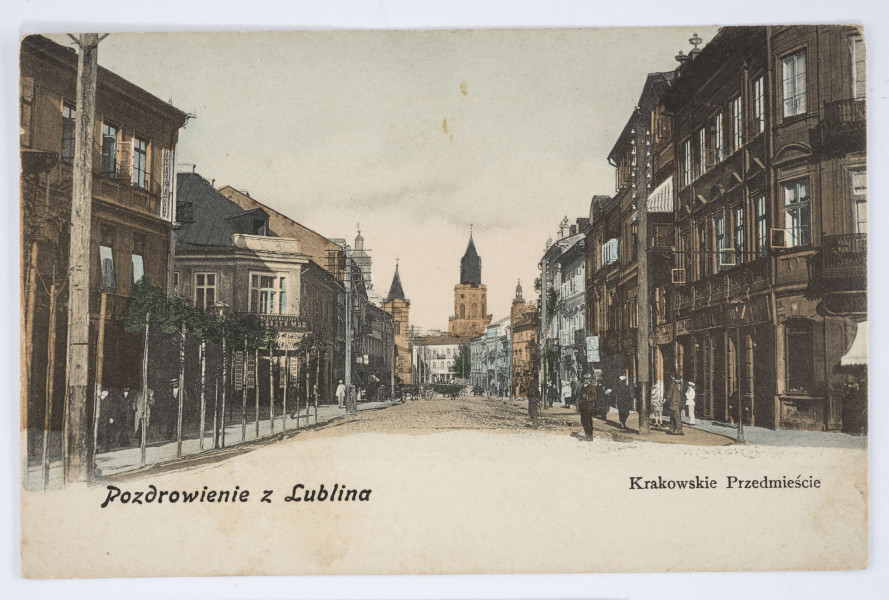 Pocztówka barwna z widokiem na ul. Krakowskie Przedmieście w Lublinie
AWERS: Widok zamykający perspektywę ulicy Krakowskie Przedmieście w kierunku Bramy Krakowskiej, na wysokości ulicy Kapucyńskiej. Po obu stronach pierzeje kamienic. W głębi Wieża Trynitarska. Po jej lewej stronie wieże kościoła p. w. Świętego Ducha oraz Nowego Ratusza; po prawej jedna z wież katedry. Ulica brukowana, oddzielona od kamienic pasami chodników i rzędami przyciętych drzew. Widoczne słupy telegraficzne oraz szyldy na budynkach. Pośrodku zaprzężony wóz. Liczni przechodnie. U dołu cieniowana fotografia przechodzi w pas białego pola z nadrukiem w kolorze czarnym. Napisy informacyjne różnym krojem czcionki. Zdjęcie utrzymane w tonacji brązowej z niebieskimi podkolorowaniami. 
REWERS: Czarna linatura. Wyznaczone pole na adres i korespondencje oraz znaczek pocztowy. Nadruk z informacją o nakładcy w kolorze czarnym wzdłuż lewej krawędzi. Napisy w języku polskim, rosyjskim i francuskim. Brak korespondencji oraz śladów obiegu pocztowego.
