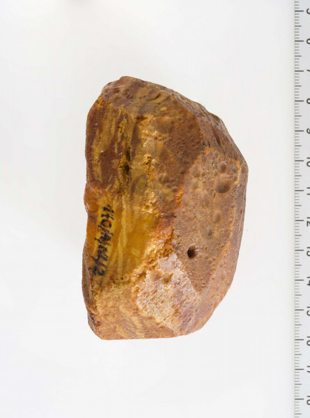 Surowiec wstępnie obrobiony, kształtem zbliżony do prostokąta. Widoczne ślady wierceń.