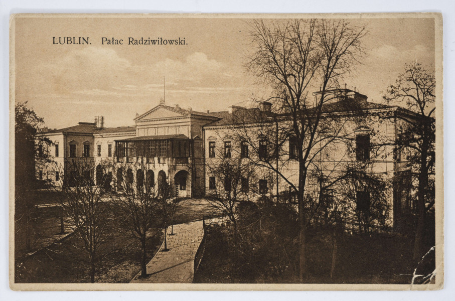 Pocztówka w sepii z widokiem Pałacu Lubomirskich (kojarzonego błędnie z Barbarą Radziwiłłówną, stąd zwanego Pałacem Radziwiłłowskim) przy placu Litewskim w Lublinie. 
AWERS: Na pierwszym planie od lewego dolnego narożnika prowadząca do pałacu aleja wyłożona kostką w jodełkę. Po obu stronach alei chodniki wyłożone płytami, obsadzone rzędami drzew pozbawionymi liści. W prawym dolnym rogu skwer z półdziko rosnącymi drzewami i krzewami. Pałac w stylu klasycystycznym, jednopiętrowy, z dwoma ryzalitami –  bocznymi i środkowym, zwieńczonym tympanonem. Przed ryzalitem portyk złożony z sześciu filarów z boniowaniem, połączonych łukami. Nad portykiem balkon z przeszkloną i zadaszoną oranżerią, porośnięty bluszczem. Po lewej stronie, w górnej części pocztówki, drukiem napis z tytułem. 
REWERS: Linatura w kolorze czarnym. W polu na korespondencję datowany tekst z nieczytelnym podpisem autora, adresowany do Państwa Bagieńskich zamieszkałych przy ul. Narutowicza 22 w Lublinie. Pismo odręczne czarnym atramentem. Treść stanowią życzenia świąteczne i noworoczne. U dołu, pod polem tekstowym, drukiem nazwa wydawcy. Pośrodku pionowy nadruk z informacją o autorach fotografii. Brak śladów obiegu pocztowego.
