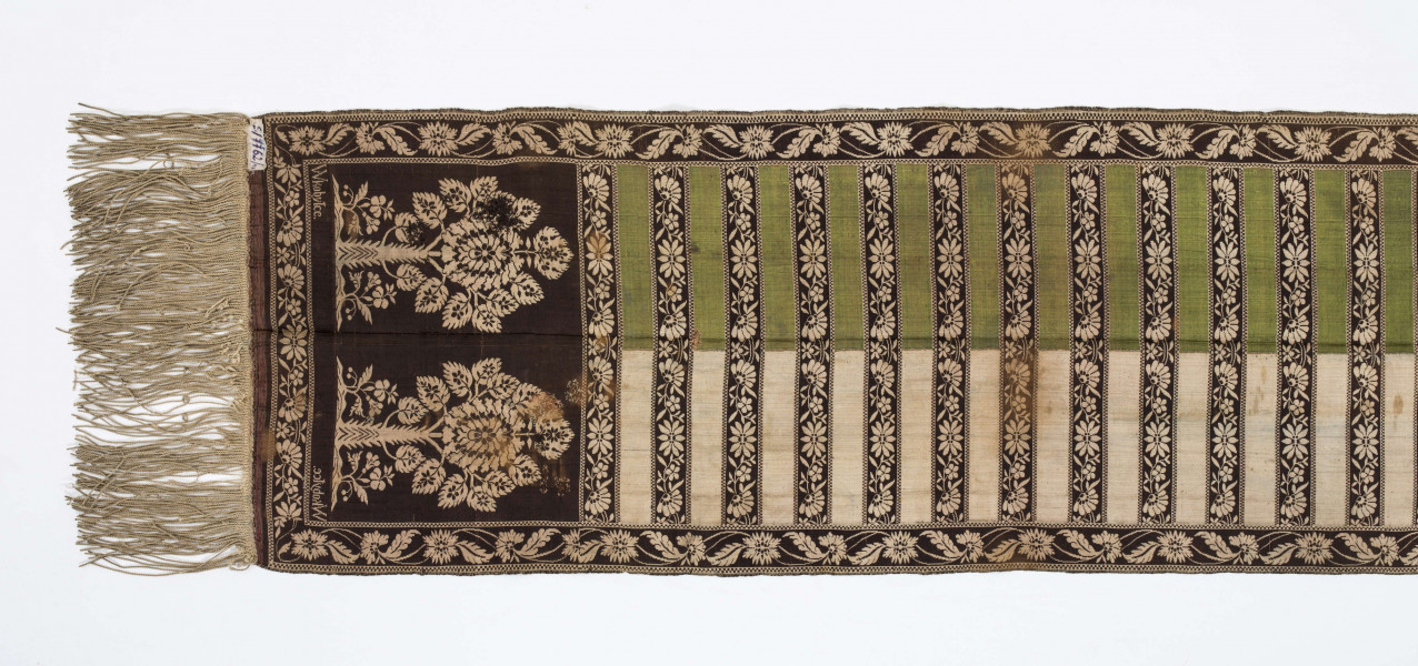 Pas kontuszowy czterostronny
Ornament
Głowy- motyw dwóch drzewek, których koronę stanowi owalna rozeta otoczona listkami, rozeta i listki wypełnione małymi kwiatkami. Drzewko wyrasta z lekko pofalowanego gruntu po bokach dwa małe krzaczki kwiatowe. 
Wciąż- pasa w poprzeczne pólka na przemian gładkie i z motywem wici kwiatowej.
Obrzeżenia- pionowe z motywem wici złożonej z kwiatów i listków palmowych, poziome jak w  pólkach.
Kolory: karmazynowy, błękitny, zielony, kremowy i brązowy
Pas sygnowany- w głowach tkany napis: S Filsjean Wkobyłce
Krótsze boki z doszytą długą frendzlą