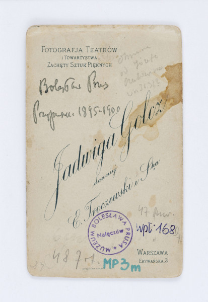 Fotografia przedstawia pisarza siedzącego na krześle. Ma krótkie włosy, na nosie znajdują się okrągłe okulary. Ubrany jest w dwuczęściowy, czarny garnitur, białą koszulę oraz ciemny krawat. Fotografia naklejona jest na tekturę firmową. W prawym, dolnym rogu znajduje się drukowany podpis fotografa: J. Golcz. Na odwrocie, w lewym, górnym rogu znajduje się drukowany napis: „FOTOGRAFJA TEATRÓW/ i towarzystwa/ Zachęty Sztuk Pięknych”. Niżej znajduje się odręczny napis wykonany flamastrem: „Bolesław Prus/ Przypuszcz. 11845 1900”. Po środku znajduje się nazwa firmy fotograficznej: „JADWIGA GOLCZ/ dawniej/ E. Troczewski i Ska”. W prawym, dolnym rogu znajduje się adres: Warszawa/ Erywańska.3.