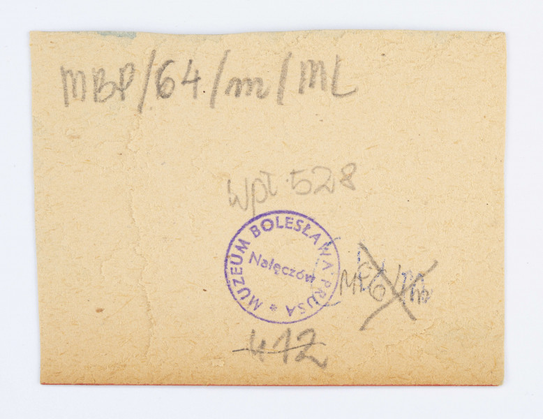 Fotografia naklejona na kawałek tektury. Oktawia Głowacka stoi na ścieżce, ubrana w białą spódnicę i żakiet. W prawej ręce trzyma czarną parasolkę. Za plecami Oktawii można zauważyć kilka drzew. Pod fotografią znajduje się podpis: O. Głowacka.