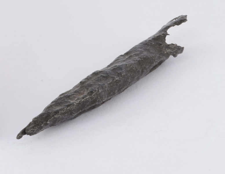 Grot żelazny kształtu lancetowatego. Ostrze z wyraźnym żeberkiem po obu stronach. Tulejka zachowana fragmentarycznie. Surowiec - żelazo. Wymiary: dł. 6,8; szer. ostrza 1; gr. ostrza 0,6 cm. Zabytek zakonserwowano i zabezpieczono przed dalszą korozją. Stan zachowania dobry.