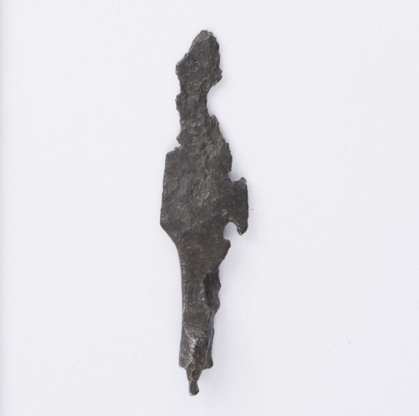 Żelazny grot strzały z wyraźnie wyodrębnionym od tulejki ostrzem; tulejka pełna, płasko sklepana w dolnej partii okrągła; zachowany mały fragment trzpienia