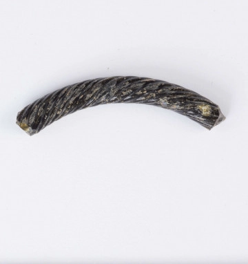1871/A/ML Fragment szklanej bransolety zdobionej kilkoma równolegle do siebie biegnącymi spiralnie wokół bransolety żłobkami. Bransoleta w przekroju okragła. Surowiec - szkło, barwa ciemno-brązowa. Wymiary: dł. 4,2; średn. 0,5 cm. Stan zachowania dobry.