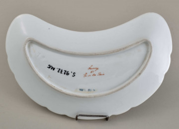 Talerzyk przystawkowy, w kształcie półksiężyca, z wyzębionym brzegiem, biały, z koroną hrabiowską. spód