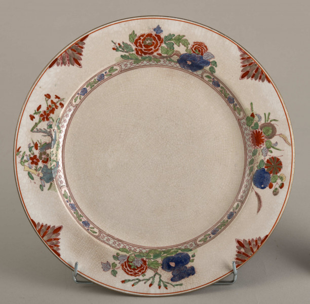 Talerz płytki, zdobiony motywem roślinnym, kwiatowym i geometrycznym w kolorze zielonym, czerwonym, niebieskim i złotym