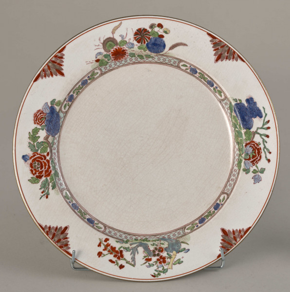 Talerz płytki, zdobiony motywem roślinnym, kwiatowym i geometrycznym w kolorze zielonym, czerwonym, niebieskim i złotym