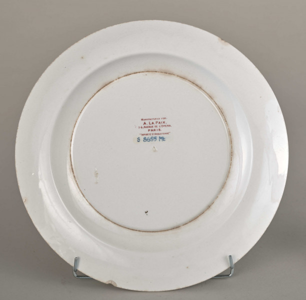 Talerz płytki, zdobiony motywem roślinnym, kwiatowym i geometrycznym w kolorze zielonym, czerwonym, niebieskim i złotym. Spód