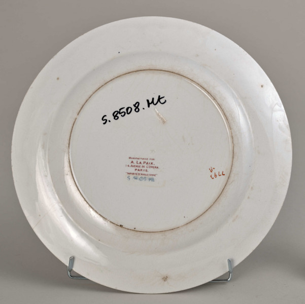 Talerz płytki, zdobiony motywem roślinnym, kwiatowym i geometrycznym w kolorze zielonym, czerwonym, niebieskim i złotym. Spód