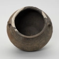Waza typu IV (Wołągiewicz) - ujęcie z góry; Naczynie ceramiczne (waza) barwy ciemno brunatnej o chropowaconej części dolnej i wygładzanej górnej partii. Waza ma dwa przewężone ucha. Na brzuścu zdobiona chropowaconymi pasami w układzie podwójnego zygzaka. Wysokość wazy wynosi 19,8 cm, średnica brzuśca 22 cm, a średnica wylewu 21 cm.