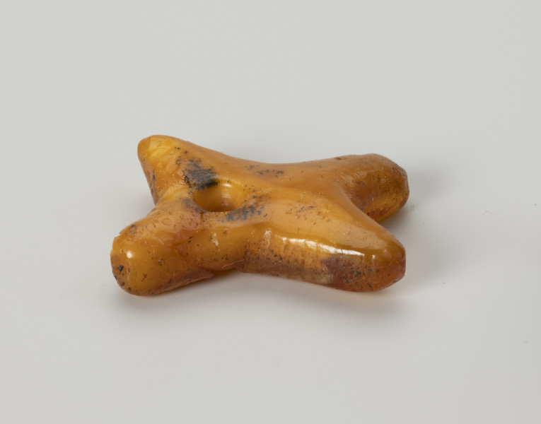 Zawieszka bursztynowa - ujęcie z boku; Zawieszka z pomarańczowego mlecznego bursztynu w kształcie litery 