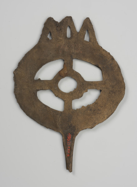 Szpila typu lüneburskiego z główką w kształcie koła szprychowego - ujęcie z dołu; Jest to szpila z brązu o okazałej kolistej główce w formie tzw. koła szprychowego - tzn. w zewnętrzy, szeroki profilowany okrąg (profilowanie stanowi imitacje trzech współśrodkowych okręgów) wpisany jest mniejszy okrąg, połączony czterema 