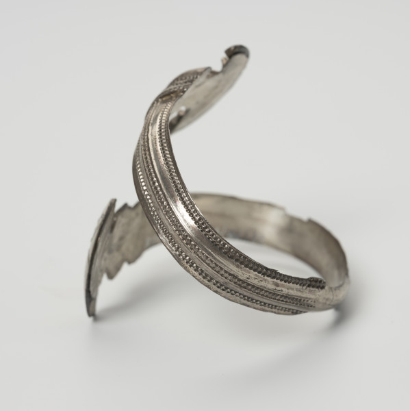 Bransoleta żmijowata - ujęcie z drugiego boku; Srebrna bransoleta żmijowata. Średnica zakończeń wynosi 2,8 – 2,9 cm. Obie główki (zakończenia) bransolety są zdobione puncą i filgranem oraz posiadają szerokie ornamentowane kryzy.