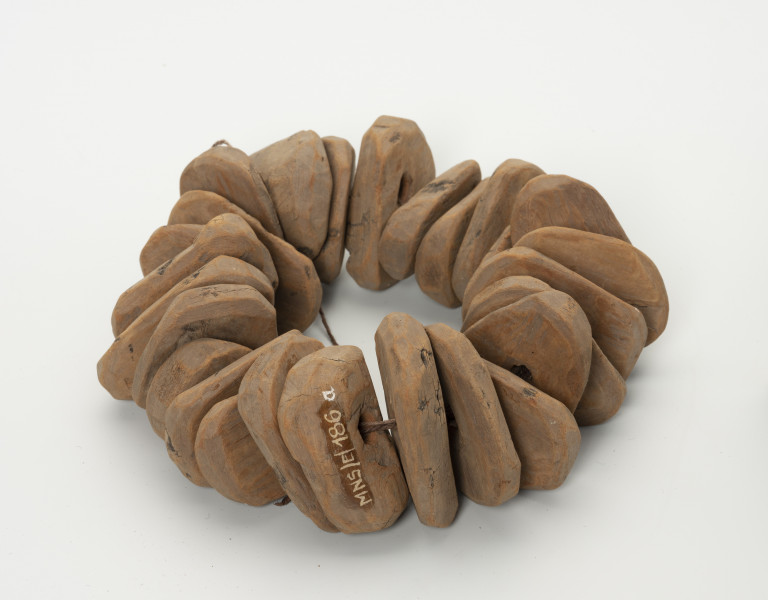 Zestaw pływaków do sieci rybackich - ujęcie z przodu; Zestaw dwudziestu sześciu pływaków sieciowych wykonanych z kory topolowej. Pływaki o podobnych rozmiarach i kształcie. Kształt w przekroju zbliżony do prostokąta o zaokrąglonych rogach. W każdym pośrodku znajduje się okrągły otwór.