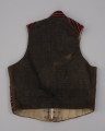 Kamizelka męska - ujęcie z tyłu; Kamizelka część męskiego stroju z półwyspu Mönchgut na Rugii/Niemcy. Plecy uszyte z tkaniny płóciennej prawdopodobnie pierwotnie w kolorze czarnym ( obecnie wyblakłym ) z charakterystycznym dla fasonu kamizelek paskiem regulującym. Podszewka z białego lnianego płótna wykonanego na krosnach tkackich splotem płóciennym prostym.