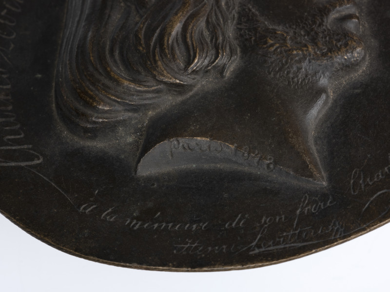 Medalion z wizerunkiem Karola Levittoux - detal; Okrągły medalion jednostronny. Widoczny wygrawerowany napis w dwóch wierszach: à la mémoire de son frère Charles | Henri Levittoux [ku pamięci swojego brata Karola | Henryk Levittoux.