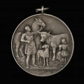 Medal nagrodowy Izby Rolniczej Prowincji Pomorze - rewers; Okrągły medal z kompozycją herbową i realistyczną, z uszkiem i koluszkiem. Na rewersie mężczyzna w fartuchu trzymający za uzdę konia, obok kobieta dojąca krowę, pośrodku stojący baran.