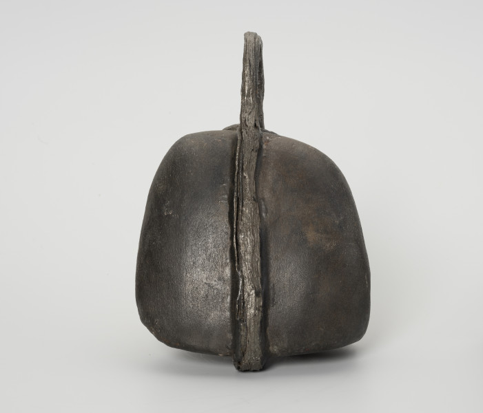 Ciężarek do sieci - ujęcie z boku; Ciężarek do obciążania sieci wykonany z szarego kamienia o gładkiej powierzchni. Kamień otoczony żelaznym, kutym pierścieniem, którego końce nie łączą się ze sobą (wtórne uszkodzenie metalu).