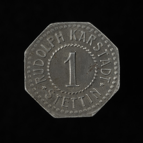1 fenig - awers; Ośmioboczna moneta domu handlowego Rudolf Karstadt w Szczecinie z gładkim rantem. Awers: w polu w sznurowej obwódce cyfra 1, powyżej między pięcioramiennymi gwiazdkami po łuku napis RUDOLF KARSTADT, a poniżej także po łuku STETTIN; obwódka zewnętrzna perełkowa.