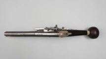 Puffer (pistolet z zamkiem kołowym) - ujęcie z góry; Lufa stalowa przy wylocie pogrubiona. W części dennej krótkie karbowania, przed nimi wybite litery H i R, a między nimi lew trzymający strzałę. Zamek wykonany ze stali. Z lewej strony blachy zamkowej bezpiecznik. Korba lekko pochylona, zakończona kolistą drewnianą głowicą.