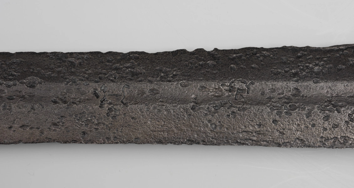 Miecz dwuręczny typu XVII (Oakeshott) - detal; Widoczny fragment żelaznego, srebrnego miecza. Fragment głowni miecza.