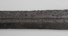 Miecz dwuręczny typu XVII (Oakeshott) - detal; Widoczny fragment żelaznego, srebrnego miecza. Fragment głowni miecza.